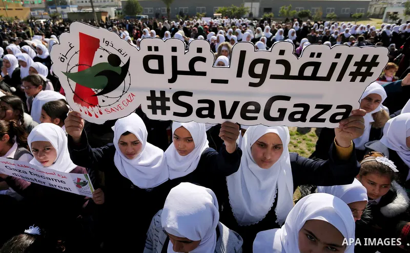 Palestinian students hold banners during a protest against Israeli blockade on Gaza strip, in Gaza city on February 4, 2018. Photo by Ashraf Amra