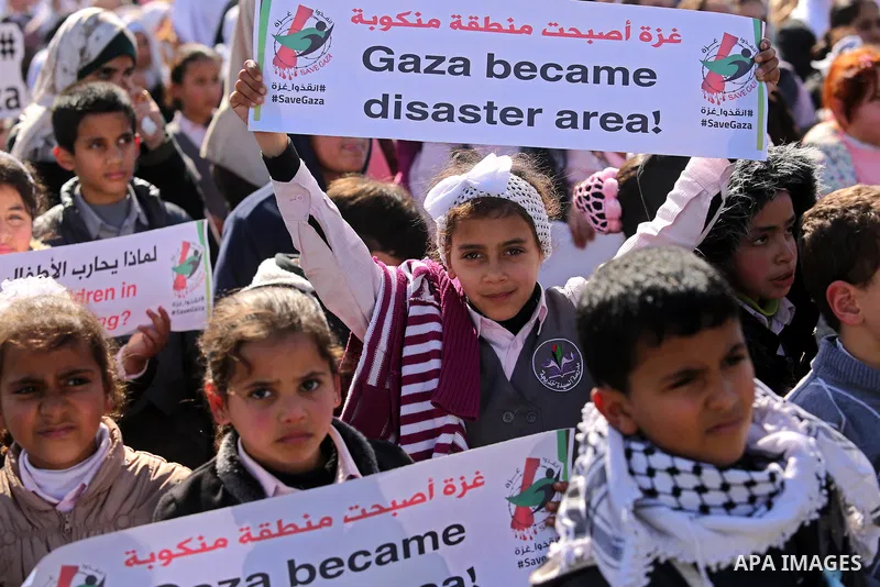 Palestinian students hold banners during a protest against Israeli blockade on Gaza strip, in Gaza city on February 4, 2018. Photo by Ashraf Amra