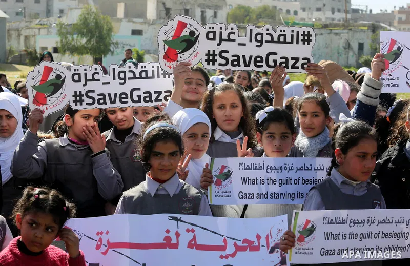 Palestinian students hold banners during a protest against Israeli blockade on Gaza strip, in Gaza city on February 4, 2018. Photo by Ashraf Amra