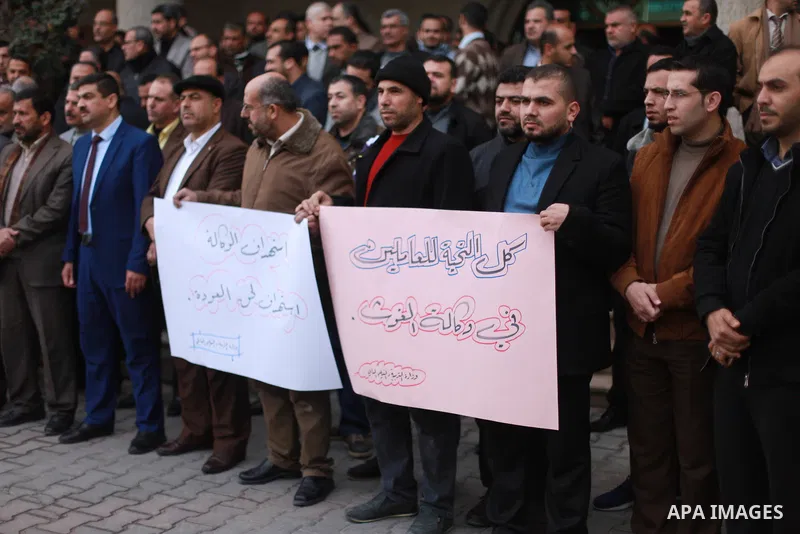 Palestinian employees of the Ministry of Education hold banners during a protest against the US move to freeze funding for the UN agency for Palestinian refugees, in Gaza city, on February 5, 2018. Photo by Mahmoud Ajour