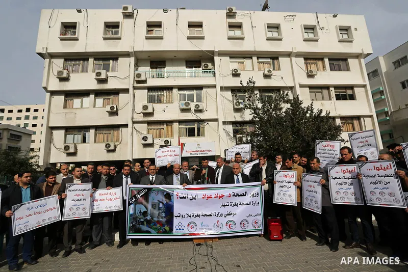 Palestinian Ministry of Health employees hold placards during a protest demanding their rights and against deterioration of health conditions in front of Ministry of Health headquarter in Gaza city on February 5, 2018. P...