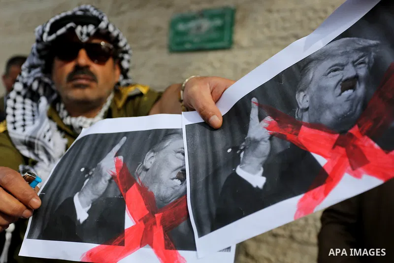 A Palestinian demonstrator burns posters of U.S. President Donald Trump during a protest to show solidarity with Palestinian prisoners held in Israeli jails, in front of Red cross office in Gaza city on February 5, 2018....