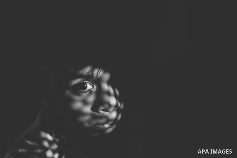 Close up of a little girl face illuminated through a window blind, Focus on one eye, High contrast, black and white. Photo by Sanad Ltefa
