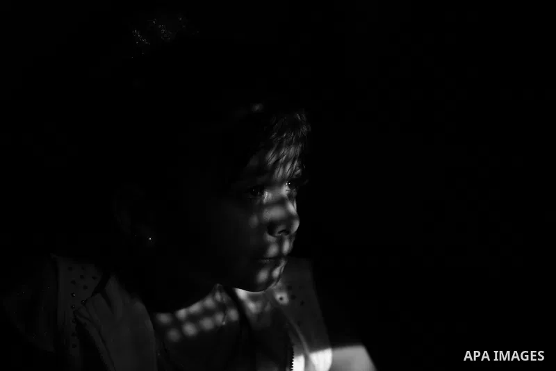 Close up of a little girl face illuminated through a window blind, Focus on the eye, High contrast, black and white. Photo by Sanad Ltefa