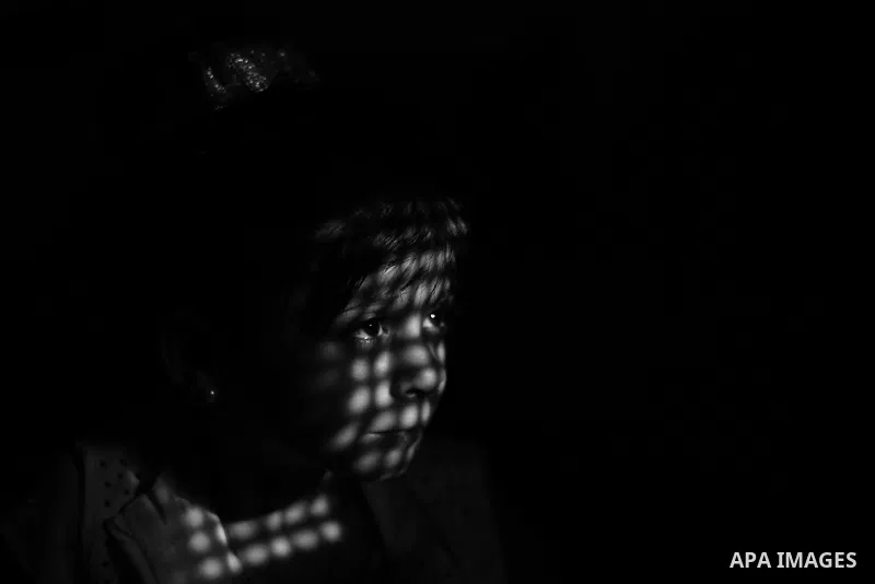 Close up of a little girl face illuminated through a window blind, Focus on the eye, High contrast, black and white. Photo by Sanad Ltefa