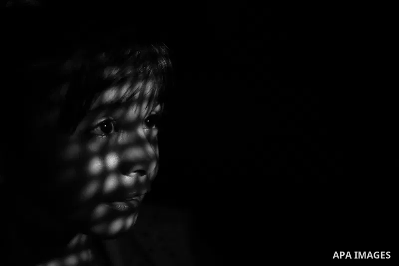 Close up of a little girl face illuminated through a window blind, Focus on the eye, High contrast, black and white. Photo by Sanad Ltefa