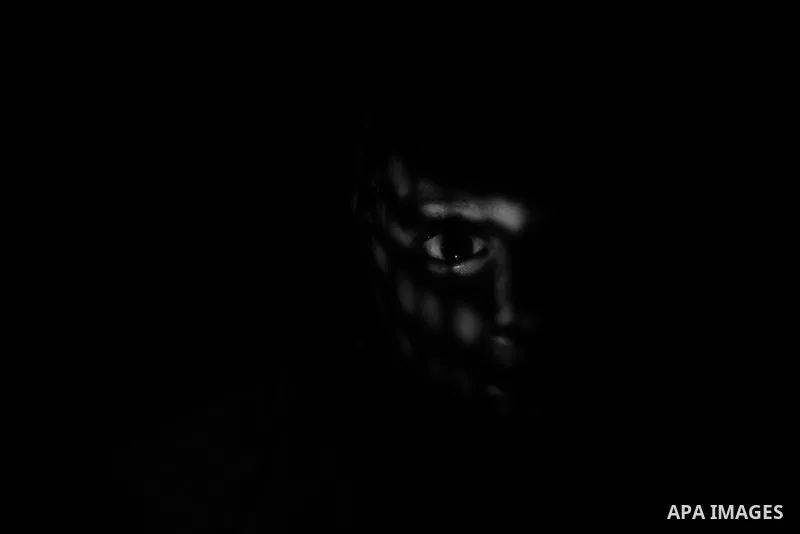 Close up of a little girl face illuminated through a window blind, Focus on one eye, High contrast, black and white. Photo by Sanad Ltefa