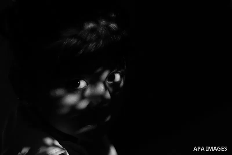 Close up of a little girl face illuminated through a window blind, Focus on the eye, High contrast, black and white. Photo by Sanad Ltefa