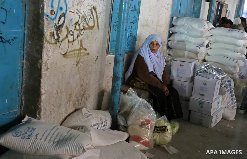Palestinian refugees collect aid parcels at a United Nations food distribution center in the southern Gaza Strip town of Rafah on February 6, 2018. Photo by Ashraf Amra