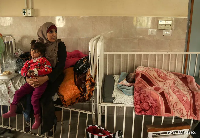 The Palestinian child is held by his mother in Dora hospital in Gaza City after it stopped its services on February 7, 2018 after it ran out of fuel. Seven medical centers in Gaza have stopped services due to lack of fue...