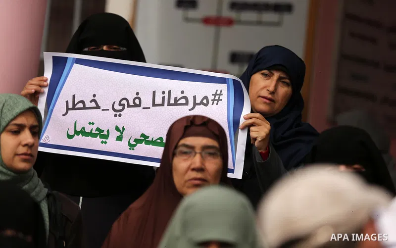 Palestinians hold placards during a protest outside Durra hospital in Gaza City after it stopped its services on February 7, 2018 after it ran out of fuel. Seven medical centers in Gaza have stopped services due to lack...
