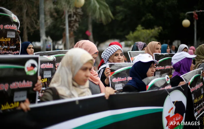 Palestinian graduates hold placards during a protest to demand their rights, in Gaza city on February 8, 2018. Photo by Ashraf Amra