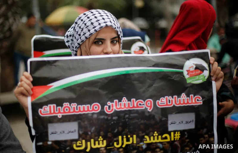 Palestinian graduates hold placards during a protest to demand their rights, in Gaza city on February 8, 2018. Photo by Ashraf Amra