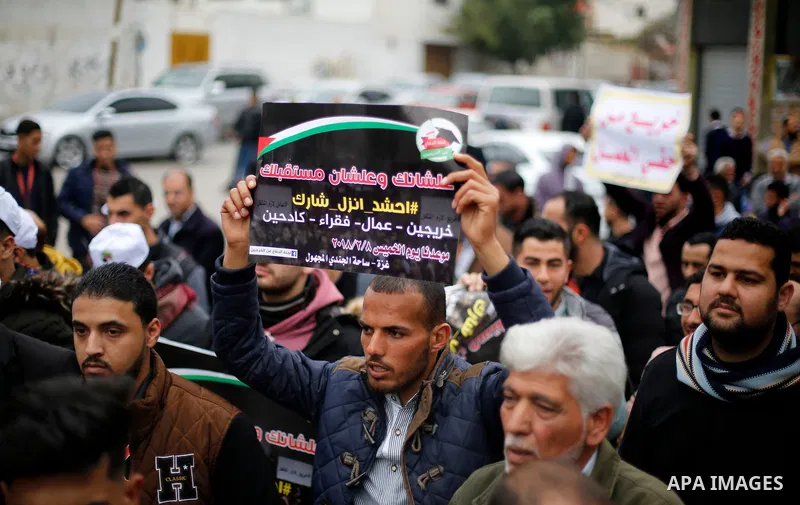 Palestinian graduates hold placards during a protest to demand their rights, in Gaza city on February 8, 2018. Photo by Ashraf Amra