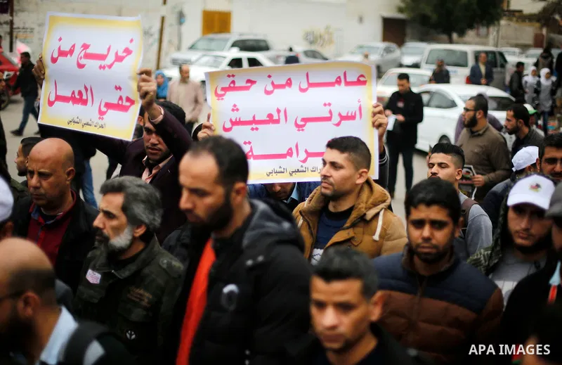 Palestinian graduates hold placards during a protest to demand their rights, in Gaza city on February 8, 2018. Photo by Ashraf Amra