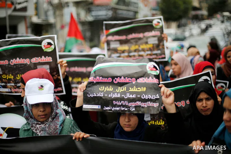 Palestinian graduates hold placards during a protest to demand their rights, in Gaza city on February 8, 2018. Photo by Ashraf Amra
