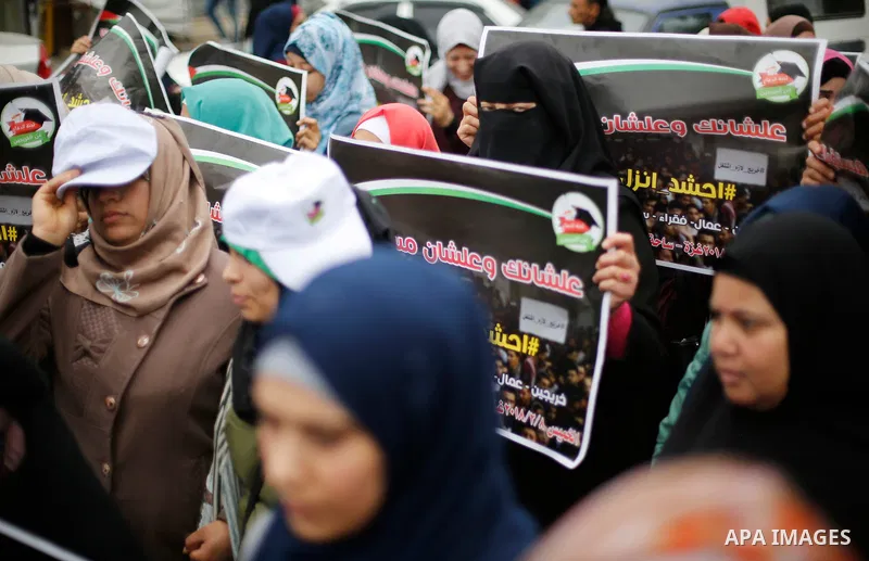 Palestinian graduates hold placards during a protest to demand their rights, in Gaza city on February 8, 2018. Photo by Ashraf Amra