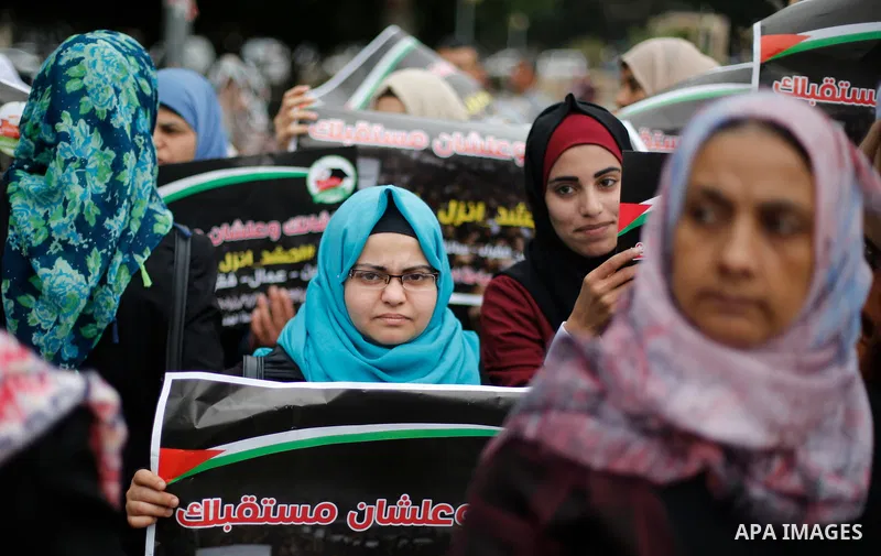 Palestinian graduates hold placards during a protest to demand their rights, in Gaza city on February 8, 2018. Photo by Ashraf Amra