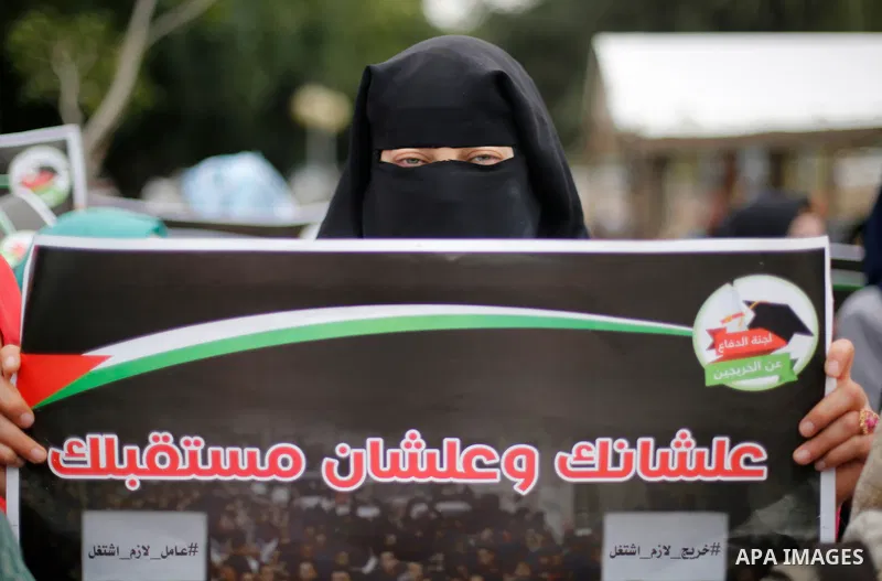 Palestinian graduates hold placards during a protest to demand their rights, in Gaza city on February 8, 2018. Photo by Ashraf Amra