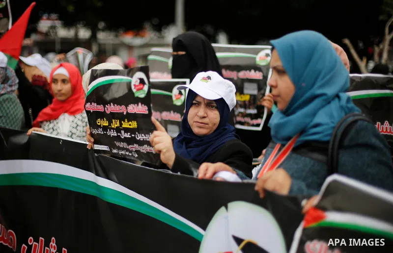 Palestinian graduates hold placards during a protest to demand their rights, in Gaza city on February 8, 2018. Photo by Ashraf Amra