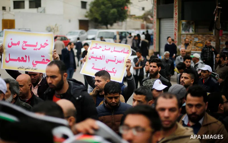 Palestinian graduates hold placards during a protest to demand their rights, in Gaza city on February 8, 2018. Photo by Ashraf Amra