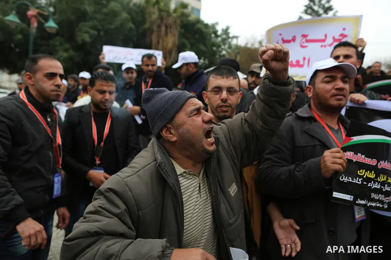 Palestinian graduates hold placards during a protest to demand their rights, in Gaza city on February 8, 2018. Photo by Ramadan El-agha