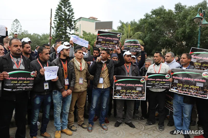 Palestinian graduates hold placards during a protest to demand their rights, in Gaza city on February 8, 2018. Photo by Ramadan El-agha