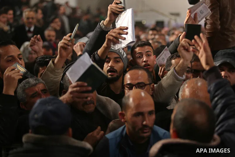 Palestinians wait for travel permits to cross into Egypt through the Rafah border crossing after it was opened by Egyptian authorities for humanitarian cases on the first time in 2018, in the southern Gaza Strip on Febru...