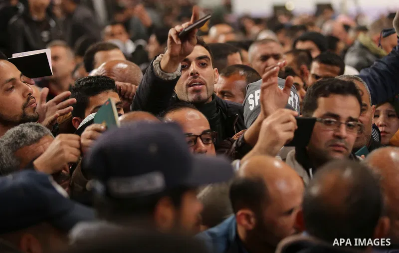 Palestinians wait for travel permits to cross into Egypt through the Rafah border crossing after it was opened by Egyptian authorities for humanitarian cases on the first time in 2018, in the southern Gaza Strip on Febru...