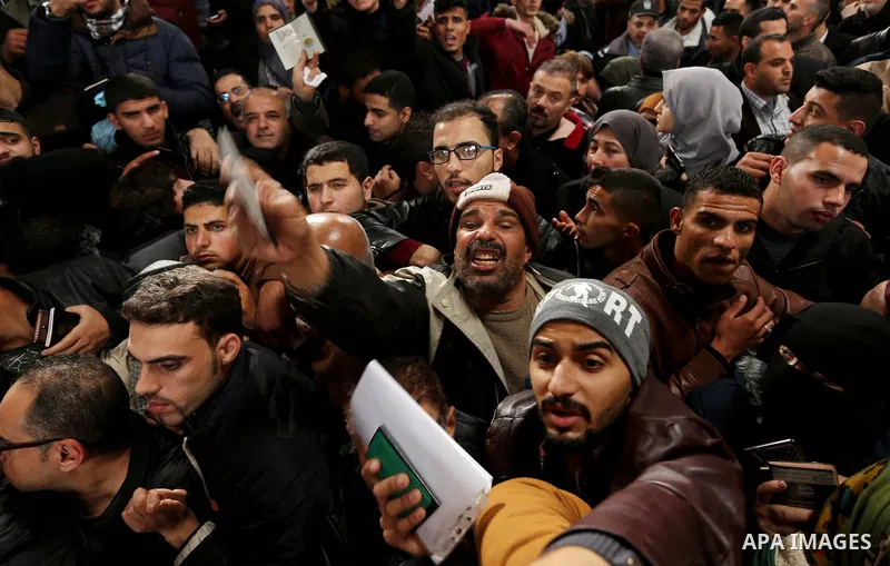 Palestinians wait for travel permits to cross into Egypt through the Rafah border crossing after it was opened by Egyptian authorities for humanitarian cases on the first time in 2018, in the southern Gaza Strip on Febru...