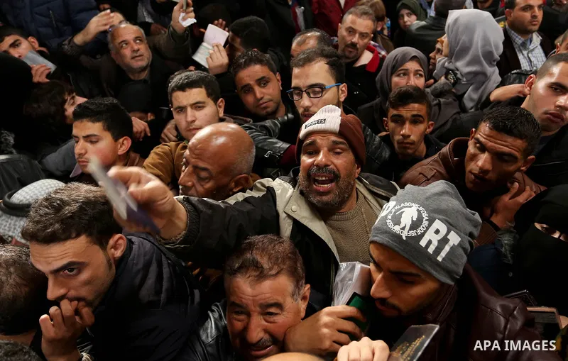 Palestinians wait for travel permits to cross into Egypt through the Rafah border crossing after it was opened by Egyptian authorities for humanitarian cases on the first time in 2018, in the southern Gaza Strip on Febru...