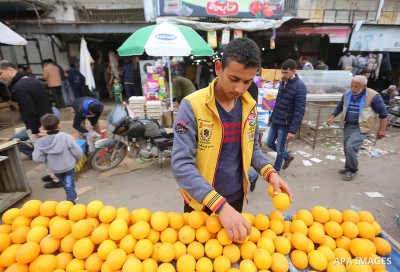 A Palestinian vendor sells vegetables and fruits at a market in Gaza city on February 8, 2018. Last two days, chicken prices in Gaza strip soared to a record high, to reach to 5$ per 1 Kg. The ongoing economic crisis in...