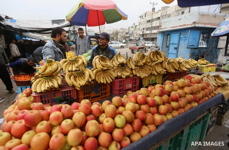 A Palestinian vendor sells vegetables and fruits at a market in Gaza city on February 8, 2018. Last two days, chicken prices in Gaza strip soared to a record high, to reach to 5$ per 1 Kg. The ongoing economic crisis in...