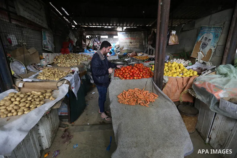 A Palestinian vendor sells vegetables and fruits at a market in Gaza city on February 8, 2018. Last two days, chicken prices in Gaza strip soared to a record high, to reach to 5$ per 1 Kg. The ongoing economic crisis in...