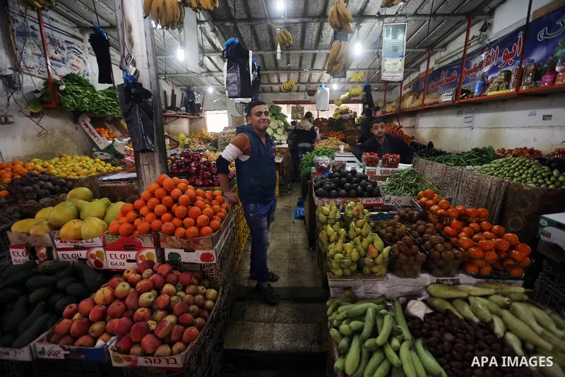 A Palestinian vendor sells vegetables and fruits at a market in Gaza city on February 8, 2018. Last two days, chicken prices in Gaza strip soared to a record high, to reach to 5$ per 1 Kg. The ongoing economic crisis in...