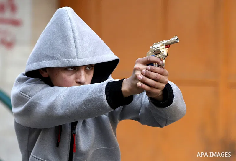A Palestinian youth brandishes a plastic cap gun during clashes with Israeli security forces as demonstrations continue over US President Donald Trump's declaration of Jerusalem as Israel's capital, in the West Bank city...