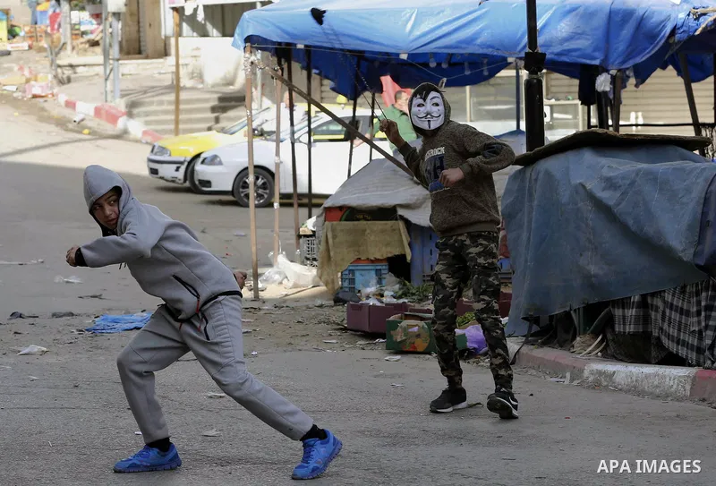 Palestinian protesters hurl stones during clashes with Israeli security forces as demonstrations continue over US President Donald Trump's declaration of Jerusalem as Israel's capital, in the West Bank city of Hebron on...