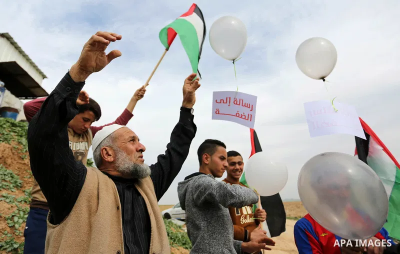 Palestinians fly balloons during a protest title "Message from Gaza to West Bank" near the border with Israel, in Jabalia in the northern Gaza Strip on February 10, 2018. Photo by Ashraf Amra