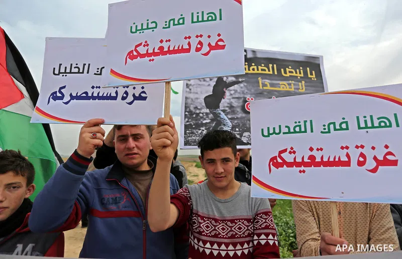 Palestinians hold national flags and placards during a protest title "Message from Gaza to West Bank" near the border with Israel, in Jabalia in the northern Gaza Strip on February 10, 2018. Photo by Ashraf Amra