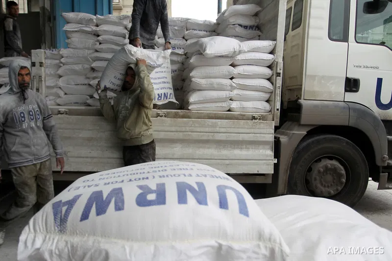 A Palestinian man unloads a sack of flour inside the United Nations' offices after receiving food supplies at the Khan Yunis refugee camp in the southern Gaza Strip on February 11, 2018. On January 16, Washington held ba...