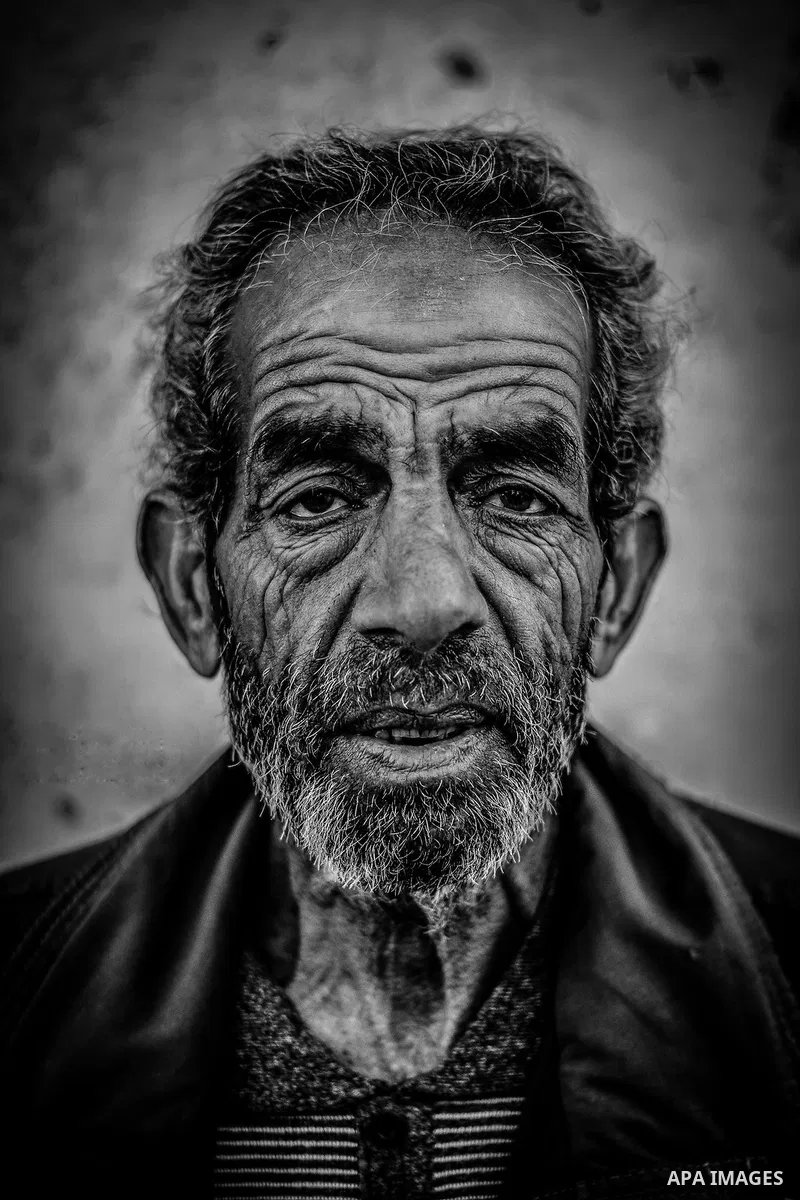 A portrait of an elderly man with wrinkled face and upset look. Photo by Sanad Ltefa