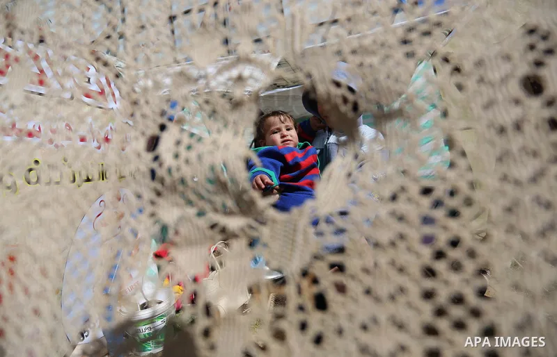 The son of a Palestinian Fadel al-Deree looks through piece of cloth outside his family tent in Gaza City, on February 13, 2017. The 55-year-old Fadel, his wife and their eight children left their apartment, where they l...