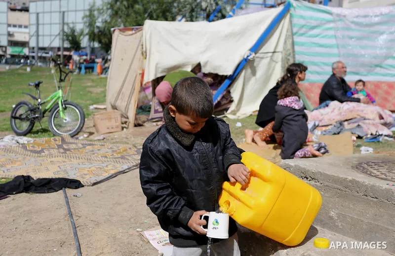 The son of a Palestinian Fadel al-Deree drinks water outside his family tent in Gaza City, on February 13, 2017. The 55-year-old Fadel, his wife and their eight children left their apartment, where they lived for twelve...