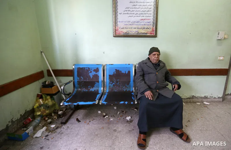 Palestinians stand near pile of waste during strike of Palestinian cleaners at al-Shifa hospital in Gaza City on February 13, 2018. Photo by Atia Darwish