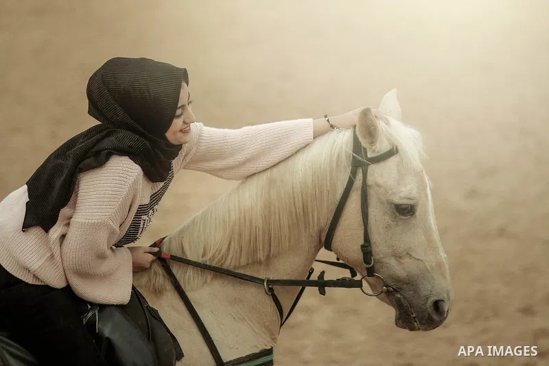 A happy woman with horse. Photo by Sanad Ltefa