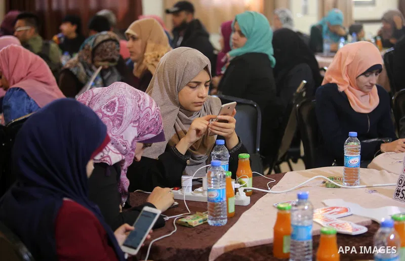 Palestinians tweet with the hashtag "#SaveGaza" against the siege on the Gaza Strip, in Gaza city, on February 14, 2018. Photo by Ashraf Amra