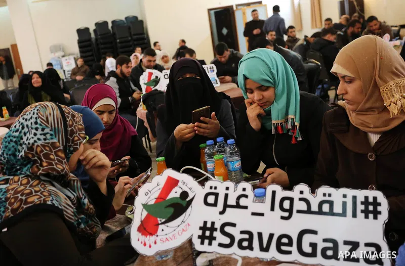 Palestinians tweet with the hashtag "#SaveGaza" against the siege on the Gaza Strip, in Gaza city, on February 14, 2018. Photo by Ashraf Amra