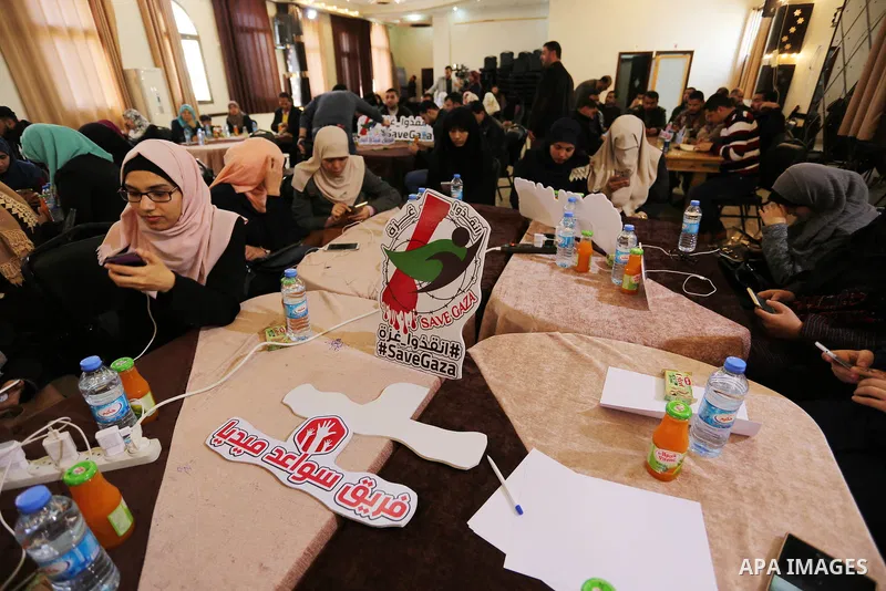 Palestinians tweet with the hashtag "#SaveGaza" against the siege on the Gaza Strip, in Gaza city, on February 14, 2018. Photo by Ashraf Amra