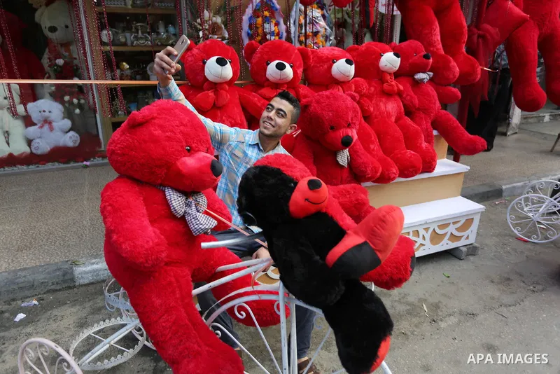 A Palestinian youth takes a selfie with red and black teddy bears on Valentine's day in Gaza city on February 14, 2018. Valentine's Day is increasingly popular in the takes region as people have taken up the custom of gi...