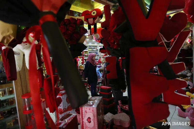 Palestinians gather at a shop selling red teddy bears, red ballons and pillows on Valentine's day in Gaza city on February 14, 2018. Valentine's Day is increasingly popular in the region as people have taken up the custo...